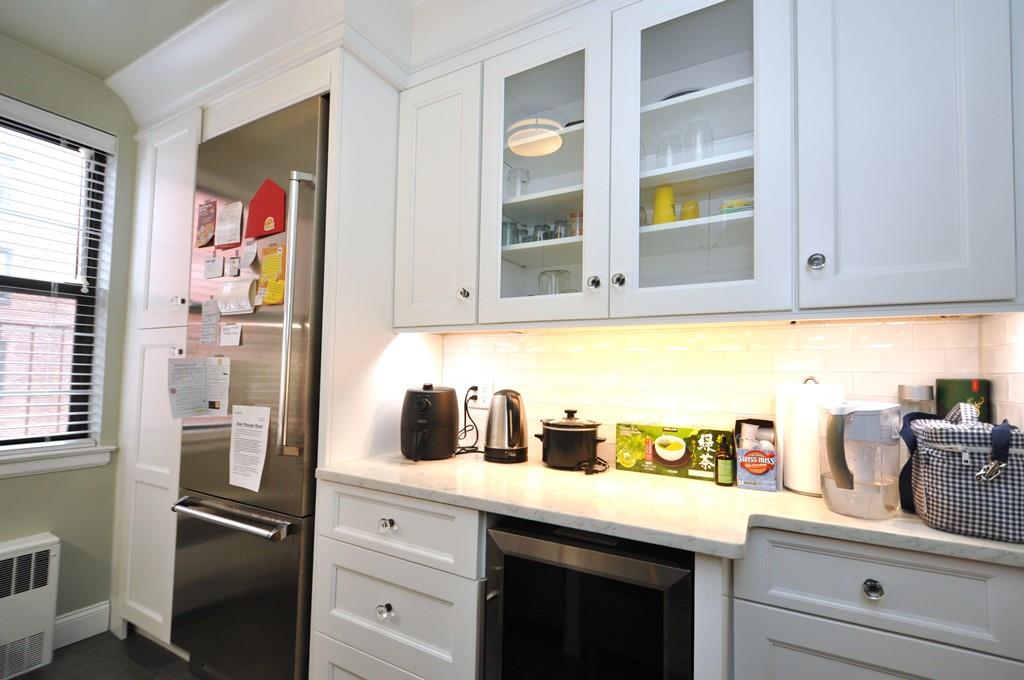 Bar with radiator, high quality fridge, beverage cooler, and white cabinets