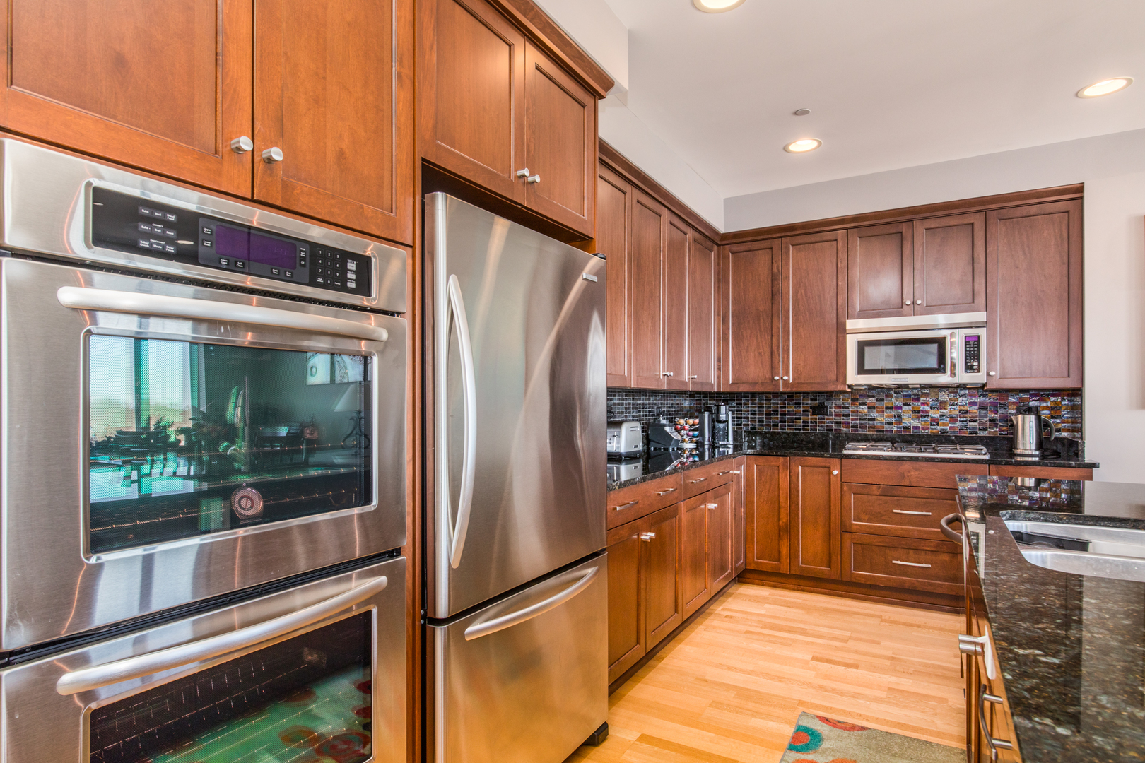 120 North Northwest Highway, Unit 506 Park Ridge, IL 60068 - Photo 5 of 20 a kitchen with stainless steel appliances granite countertop a refrigerator a stove and a sink with wooden floor