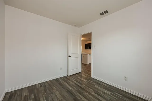 a view of a room with wooden floor and brick walls