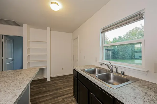a kitchen with sink cabinets and a wooden floor