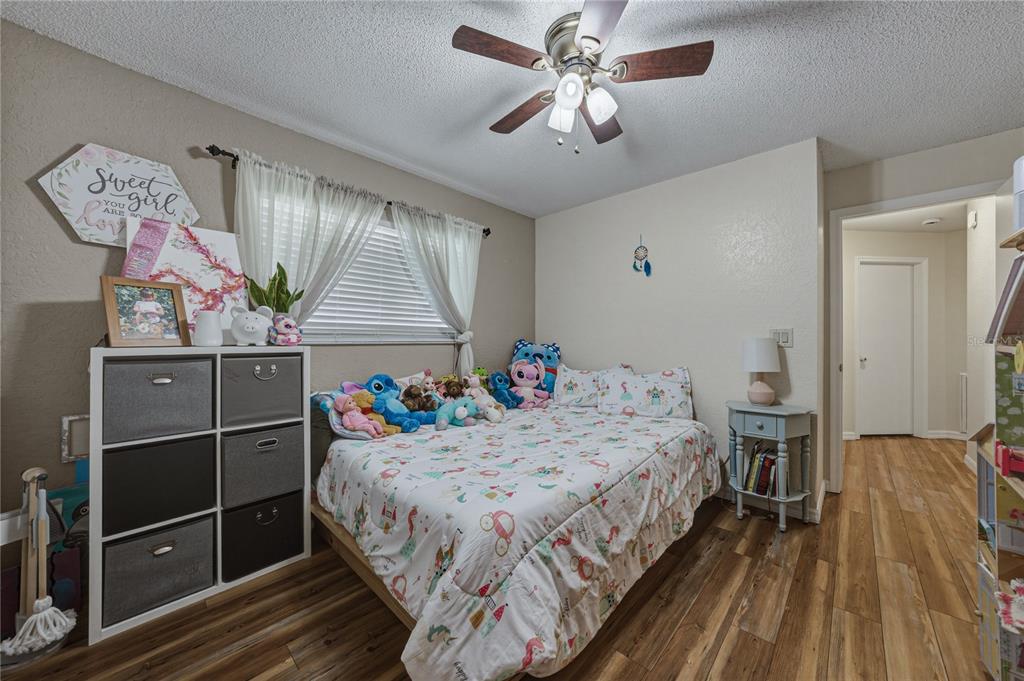 7435 Kilbride Court Weeki Wachee, FL 34613 - Photo 32 of 67 a bedroom with a bed and a chandelier