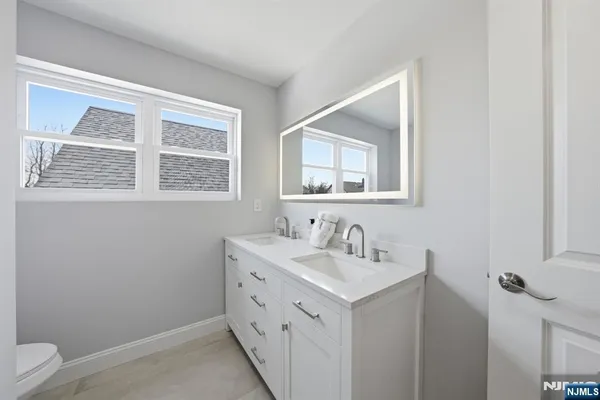 a bathroom with a sink vanity and a toilet