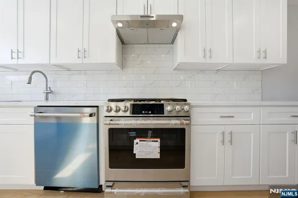 a stove top oven sitting inside of a kitchen