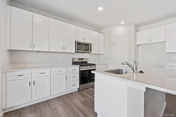 a kitchen with appliances a sink and cabinets