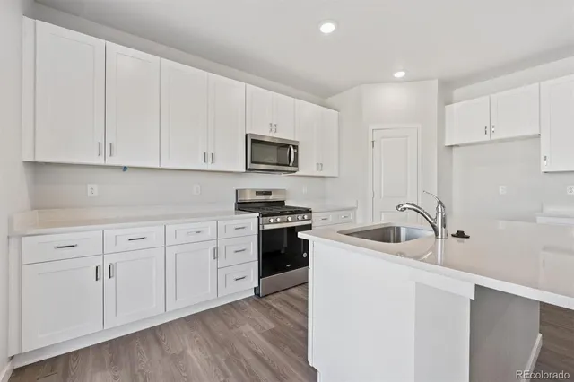 a kitchen with appliances a sink and cabinets