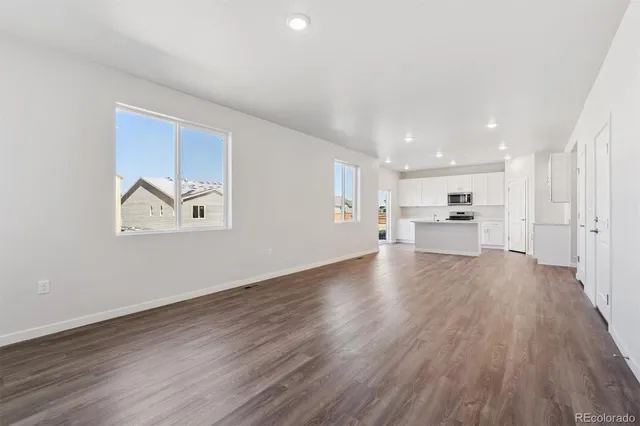 a view of kitchen and hall with wooden floor
