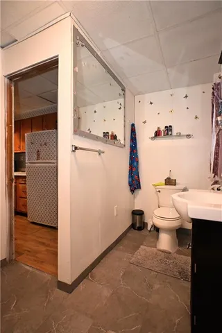 a room with painting on the wall and a view of bathroom