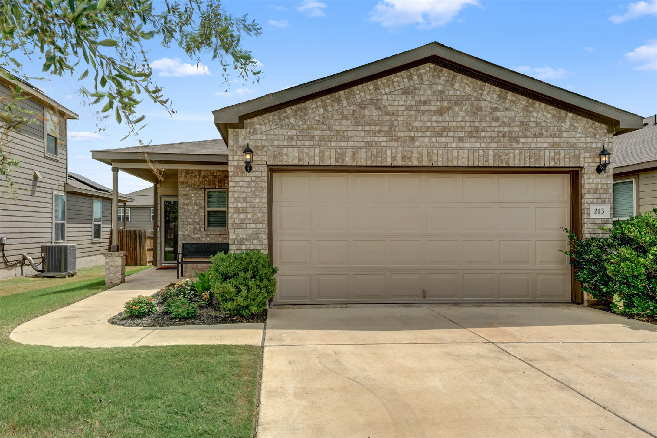 213 Ibis Falls Loop Jarrell, TX 76537 - Photo 2 of 37 A classic brick facade welcomes you to this inviting residence, complete with an attached garage and well-maintained landscaping.