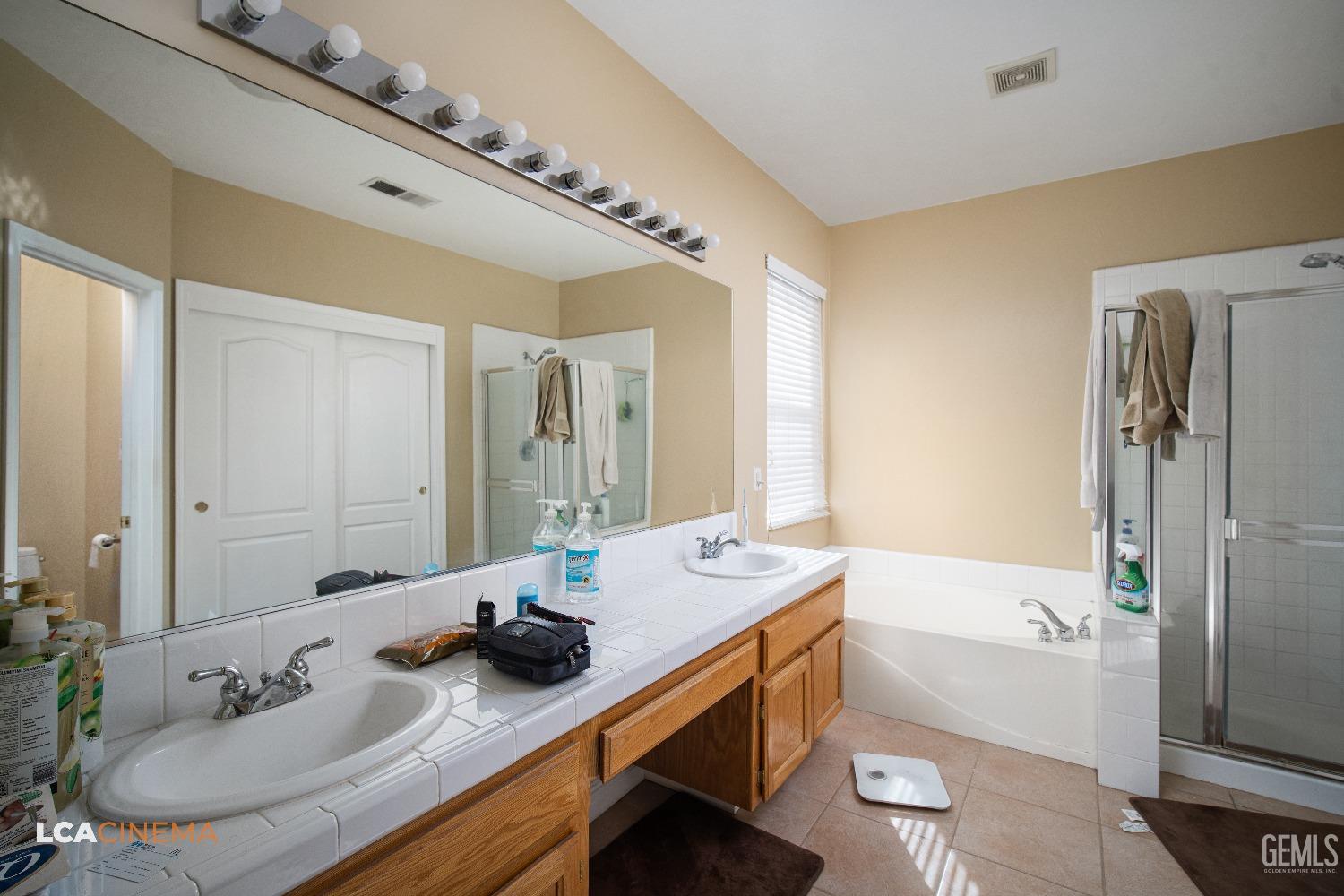Undisclosed Address Bakersfield, CA 93311 - Photo 25 of 43 a bathroom with a granite countertop sink a mirror and a bathtub