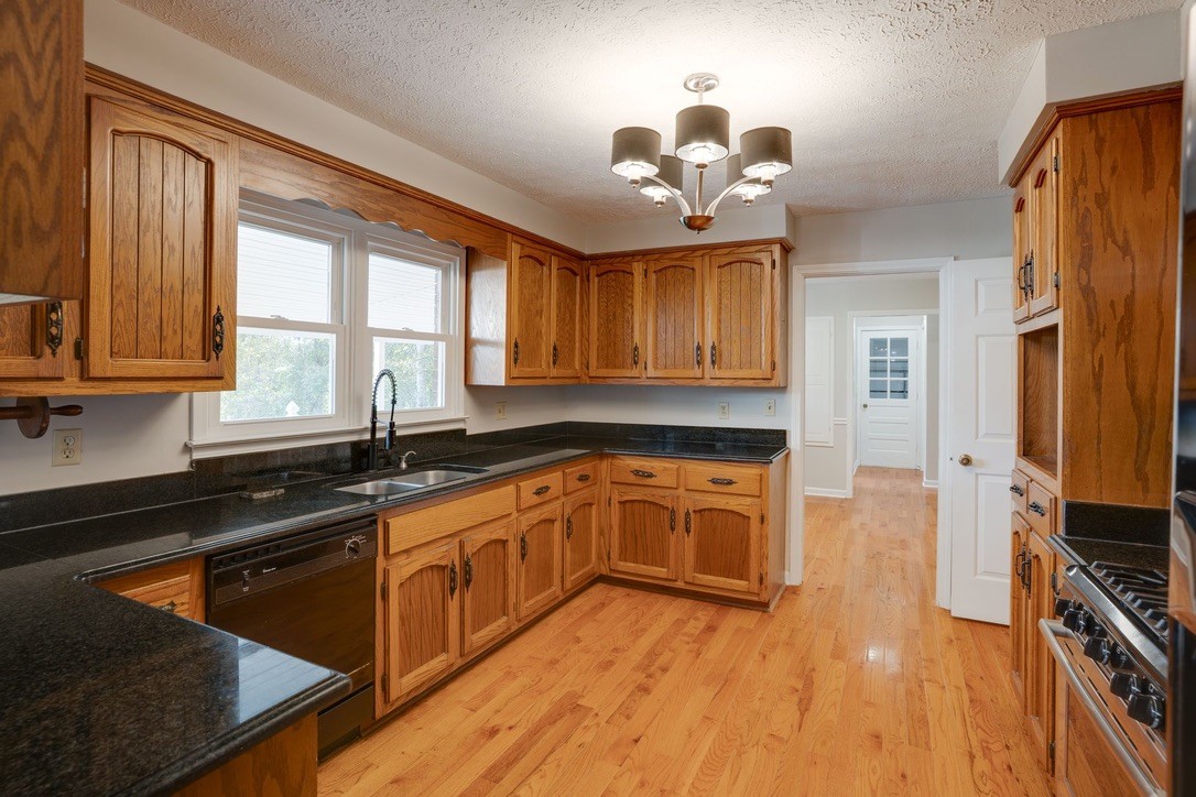 418 Spout Spring Road Dover, TN 37058 - Photo 14 of 36 a kitchen with stainless steel appliances granite countertop wooden cabinets a stove top oven a sink and dishwasher with wooden floor