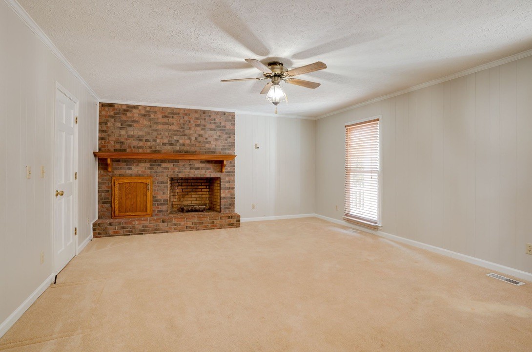 418 Spout Spring Road Dover, TN 37058 - Photo 16 of 36 a view of an empty room with a fireplace and a window