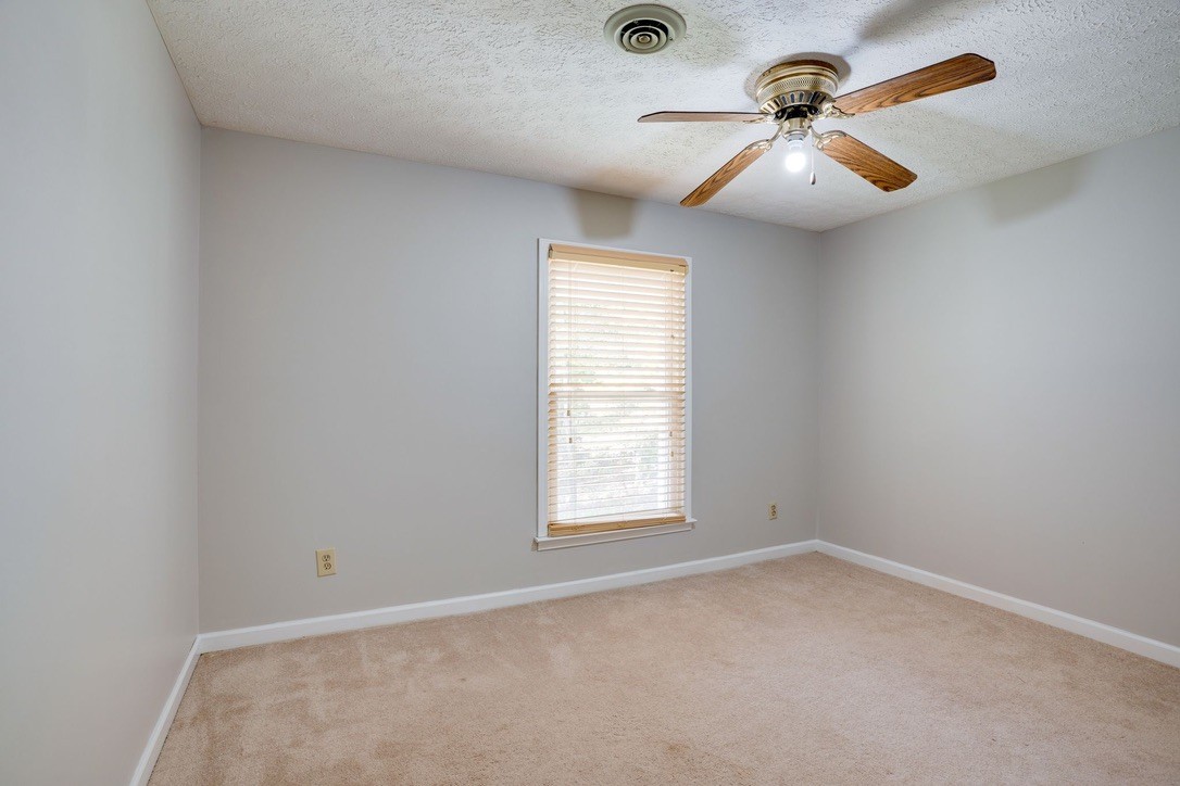 418 Spout Spring Road Dover, TN 37058 - Photo 23 of 36 an empty room with a chandelier fan and windows