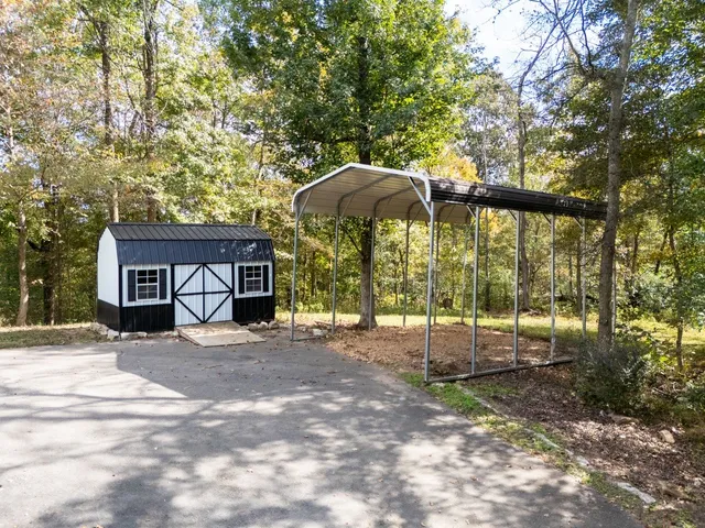 an aerial view of a house with swimming pool and large trees