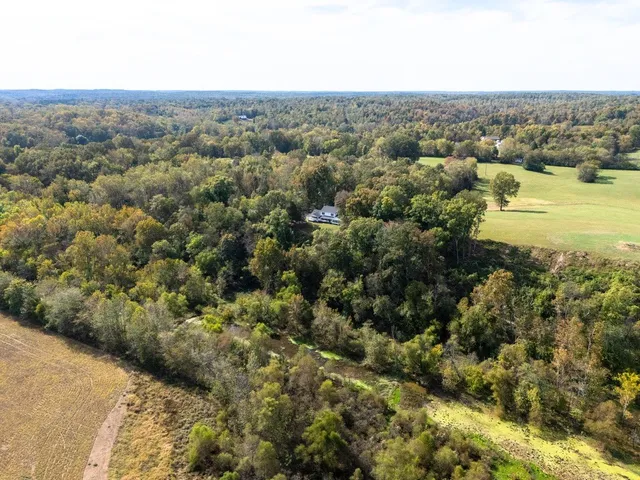 an aerial view of residential houses with outdoor space and lake view