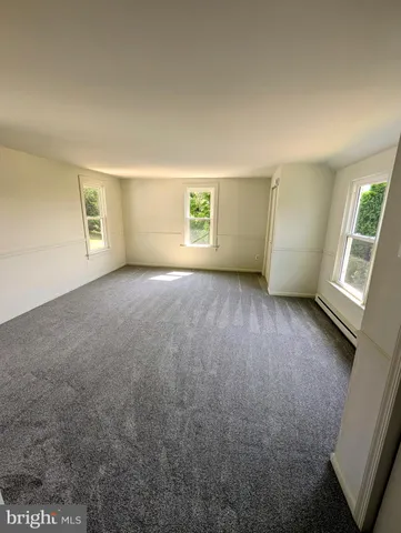an empty room with windows and closet
