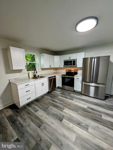 a kitchen with stainless steel appliances granite countertop a refrigerator sink and stove