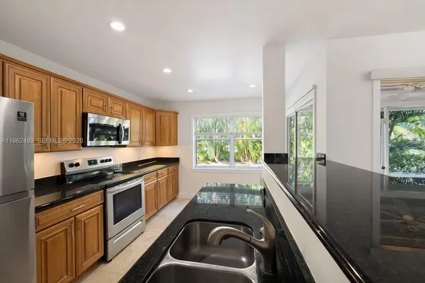 a kitchen with stainless steel appliances granite countertop a stove a sink and a refrigerator