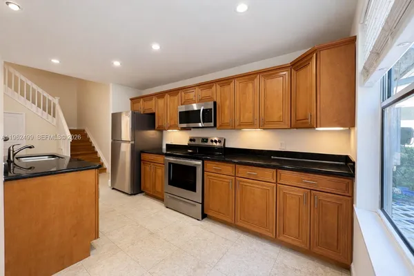 a kitchen with stainless steel appliances granite countertop a stove a sink and a refrigerator