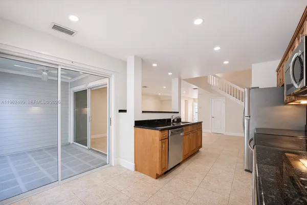 a kitchen with stainless steel appliances granite countertop a refrigerator and a sink