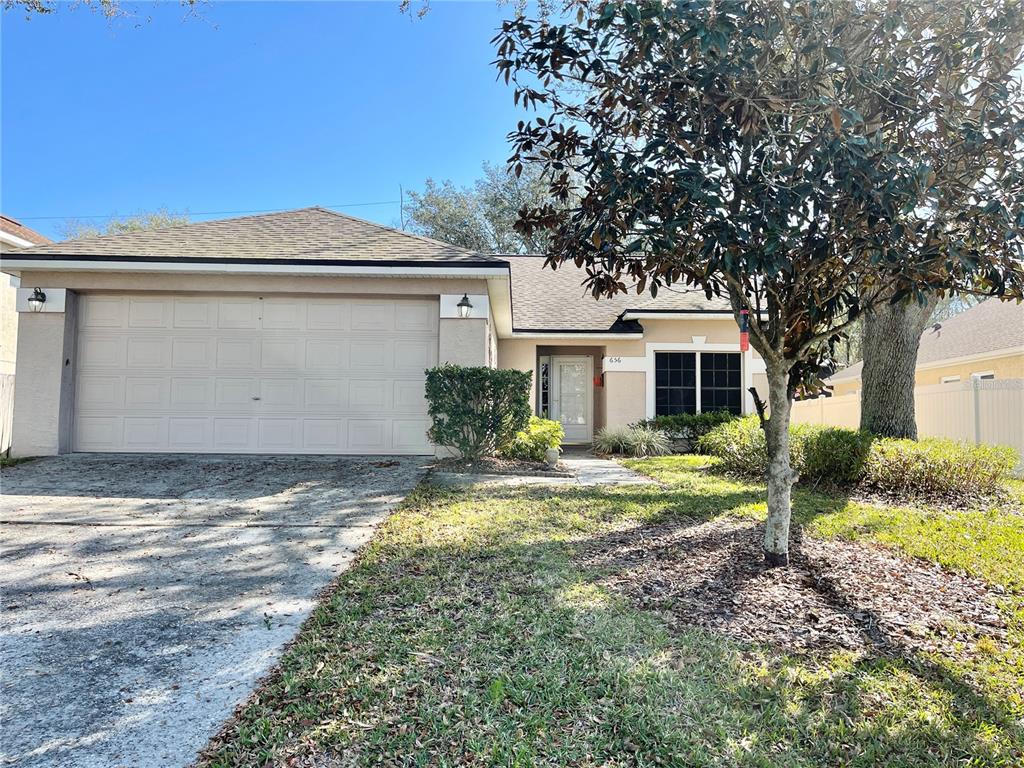a view of a house with backyard and a tree
