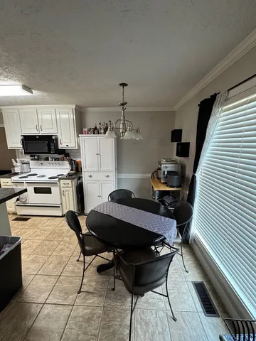 a kitchen with a stove a refrigerator and furniture