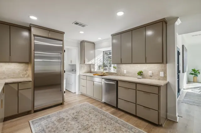 a kitchen with kitchen island granite countertop cabinets and refrigerator