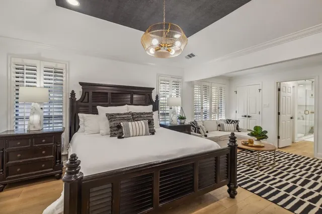 a bedroom with a bed and a chandelier