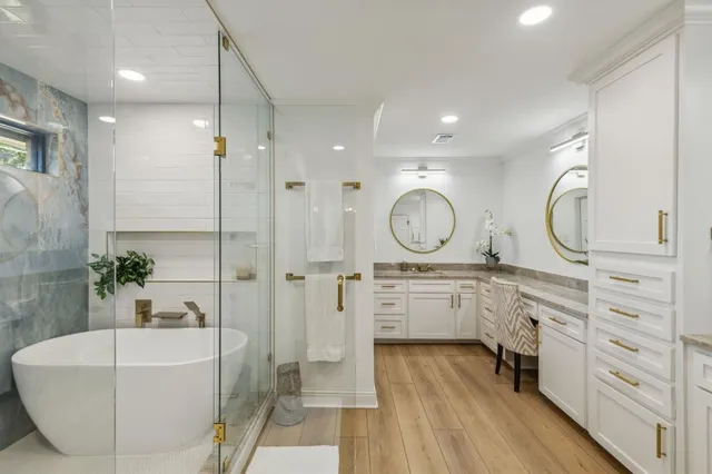 a spacious bathroom with a double vanity sink a mirror a bathtub and shower