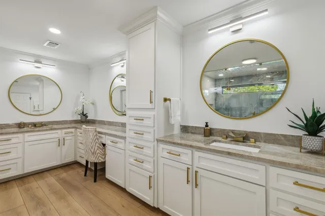 a bathroom with a granite countertop double vanity sink and a mirror