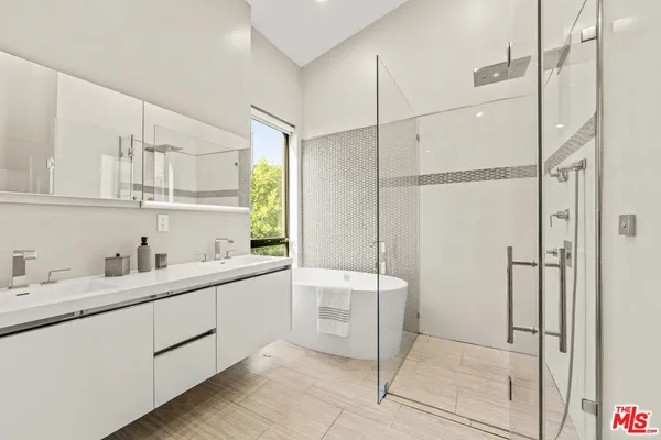 a bathroom with a double vanity sink a mirror and a shower