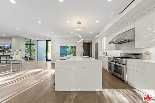 a large kitchen with stainless steel appliances kitchen island a large counter top and a stove top oven