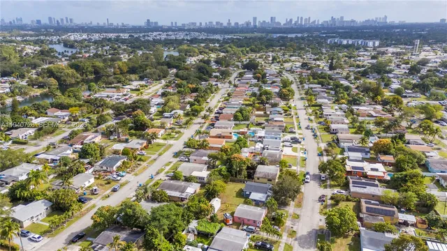 an aerial view of residential houses with outdoor space and trees