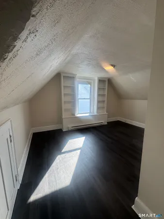 a view of empty room with wooden floor