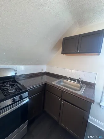 a kitchen with granite countertop a stove and a sink