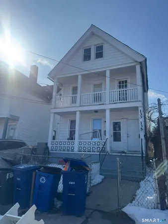 a view of a house with wooden deck and furniture