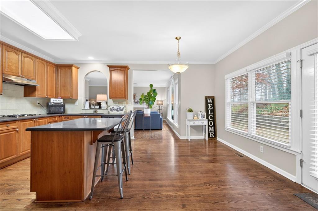 2641 Hillgrove Drive Dacula, GA 30019 - Photo 18 of 57 a open kitchen with stainless steel appliances granite countertop a stove top oven a sink a dining table and chairs with wooden floor