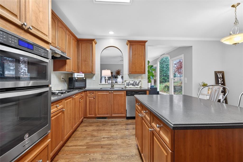 2641 Hillgrove Drive Dacula, GA 30019 - Photo 19 of 57 a kitchen with stainless steel appliances granite countertop a sink a stove and a wooden floors