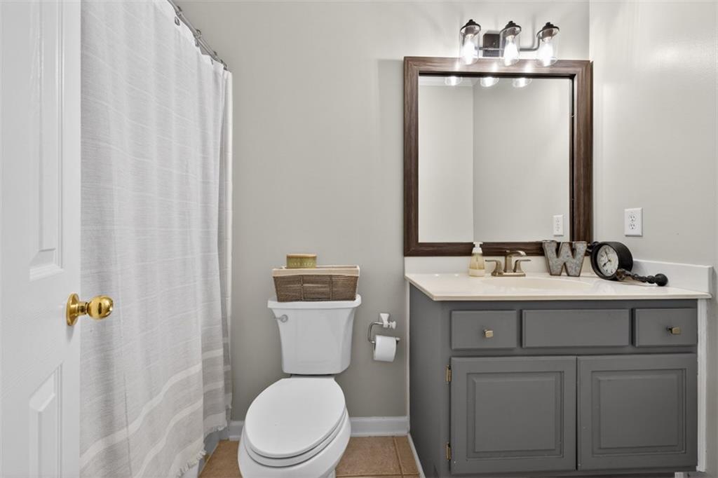 2641 Hillgrove Drive Dacula, GA 30019 - Photo 24 of 57 a bathroom with a toilet a sink a mirror and vanity