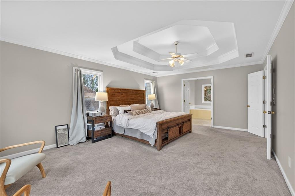 2641 Hillgrove Drive Dacula, GA 30019 - Photo 28 of 57 a spacious bedroom with a bed and a chandelier