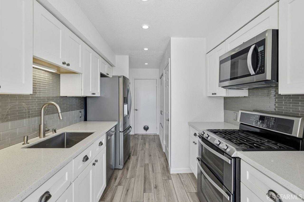 59 Kiska Road San Francisco, CA 94124 - Photo 11 of 46 a kitchen with stainless steel appliances granite countertop a sink stove and refrigerator