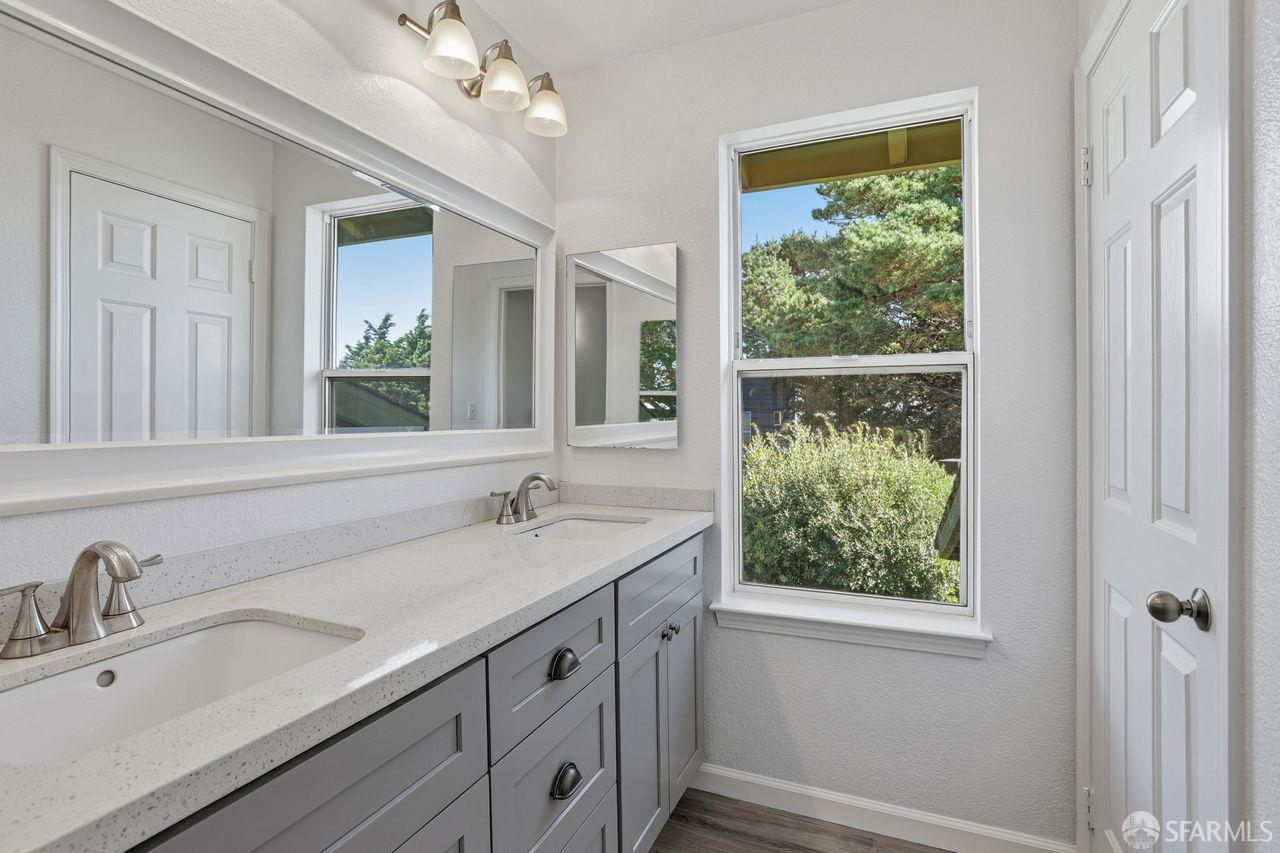 59 Kiska Road San Francisco, CA 94124 - Photo 19 of 46 a bathroom with a granite countertop sink a large mirror a and window