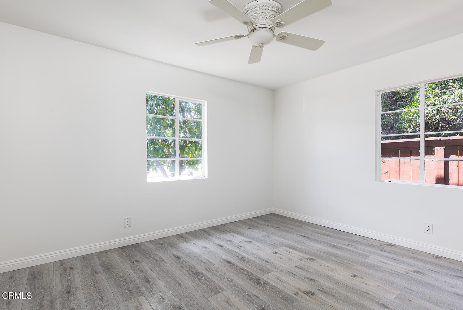 114 South Canyon Boulevard Monrovia, CA 91016 - Photo 14 of 32 an empty room with wooden floor chandelier fan and windows