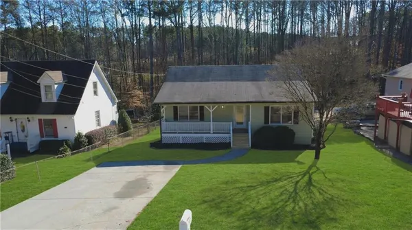 a view of house with backyard and outdoor seating