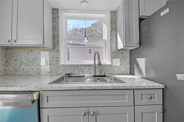 a kitchen with granite countertop a sink and cabinets