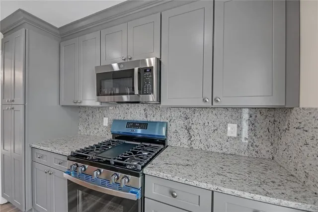 a kitchen with granite countertop white cabinets stainless steel appliances and a sink