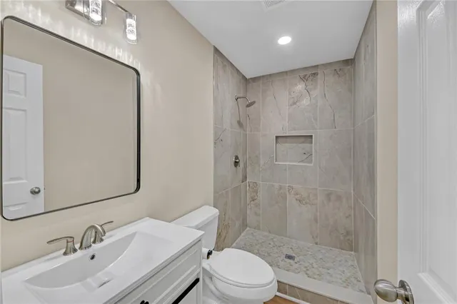 a bathroom with a sink a toilet and shower