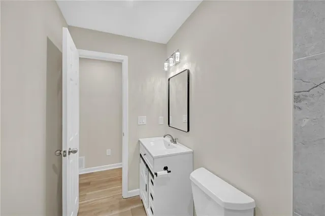 a bathroom with a toilet a sink and mirror