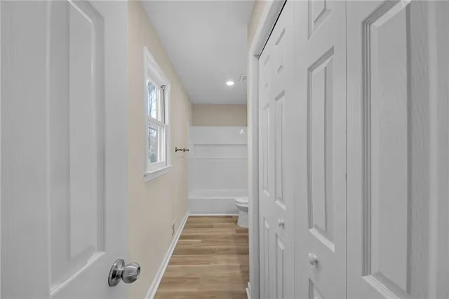 a view of a hallway with wooden floor and staircase