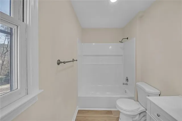 a bathroom with a granite countertop toilet a sink and bathtub