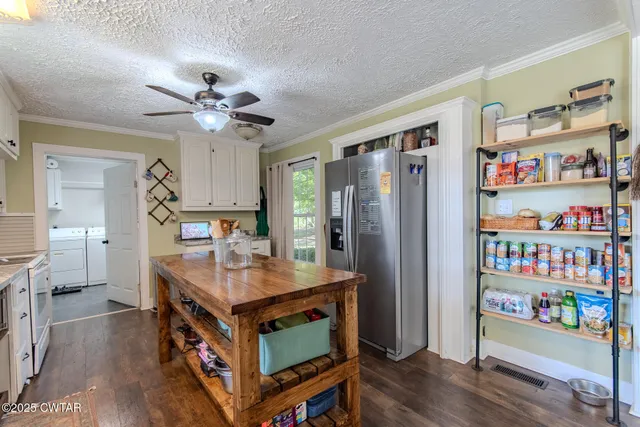 a kitchen with stainless steel appliances granite countertop a refrigerator a stove a sink and a dining table with wooden floor